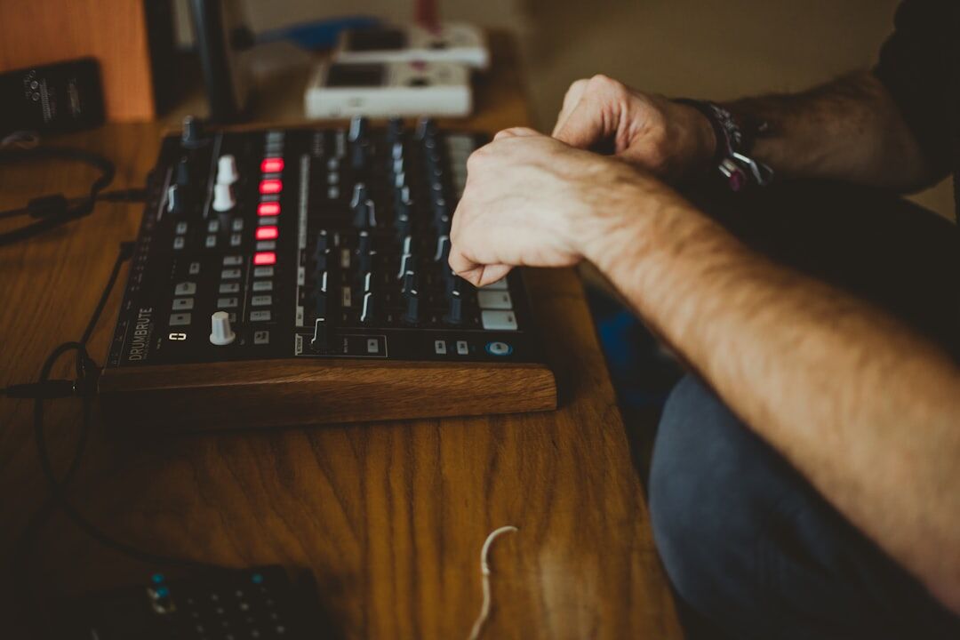 Close-up of hands on a video editing keyboard and jog wheel controller