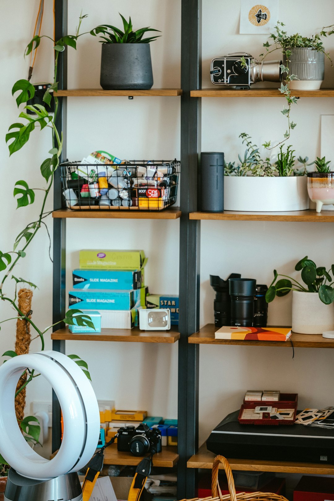 Bright creative workspace desk with camera equipment on shelves